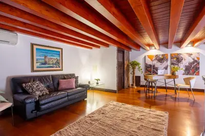 a living room with a leather couch and a table at Behind the Cathedral apt in Palermo