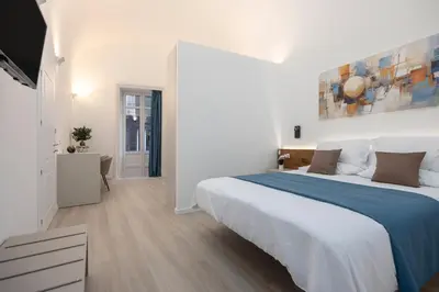 a white bedroom with a large white bed in it at Roccella Apartments in Palermo