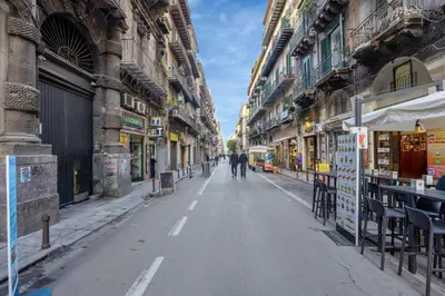 an empty city street with people walking down it at Roccella Apartments in Palermo