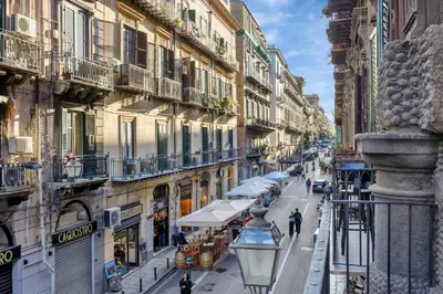 a city street with buildings and people walking down a street at Roccella Apartments in Palermo