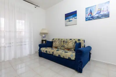 a blue couch sitting in a living room at Casa Joya Apartment in Isola delle Femmine