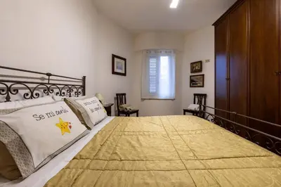 a bedroom with a large bed with a yellow blanket on it at Casa Joya Apartment in Isola delle Femmine