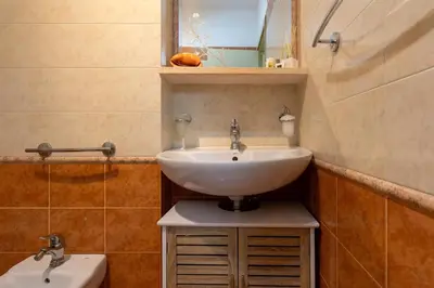 a bathroom with a sink and a mirror and a toilet at Casa Joya Apartment in Isola delle Femmine