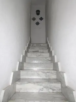 a staircase in a building with white walls and concrete steps at Camera con bagno cucina e terrazza al Vicoletto al Massimo in Palermo