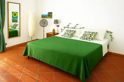 a bedroom with a bed with a green blanket at Camera con bagno cucina e terrazza al Vicoletto al Massimo in Palermo