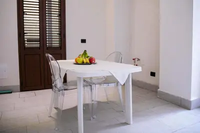 a white table with chairs and a bowl of fruit on it at Suite del Principe - Prince's Suite. in Palermo