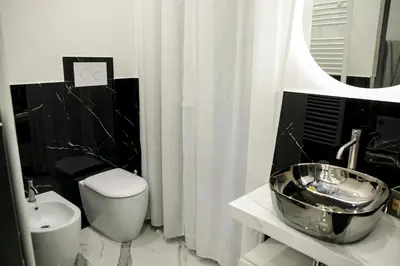 a black and white bathroom with a sink and a toilet at Suite del Principe - Prince's Suite. in Palermo