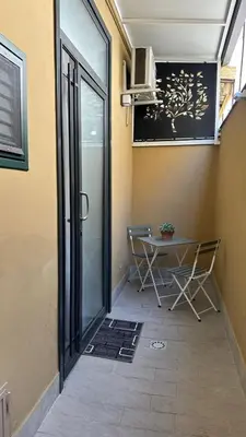 a patio with a table and chairs in a room at Villafranca settantuno Apartments in Palermo