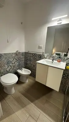 a bathroom with a toilet and a sink and a mirror at Villafranca settantuno Apartments in Palermo