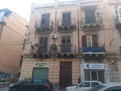 a building with cars parked in front of it at Casa Ore-Tea in Palermo