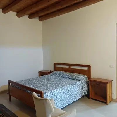 a bedroom with a bed and a chair at Casa vacanza Acquanuova in Calatafimi