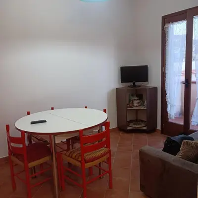 a living room with a table and chairs and a tv at Casa vacanza Acquanuova in Calatafimi