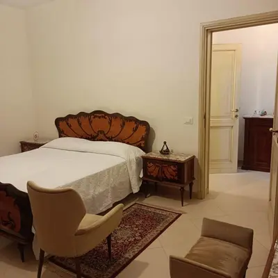 a bedroom with a bed and a chair and a table at Casa vacanza Acquanuova in Calatafimi
