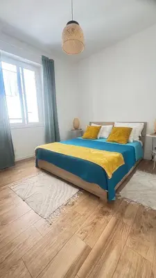 a bedroom with a bed with blue and yellow sheets at N&L Apartments Palermo in Palermo