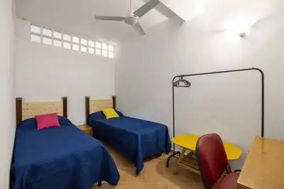 a room with two beds and a table and a desk at alloggio in Palermo