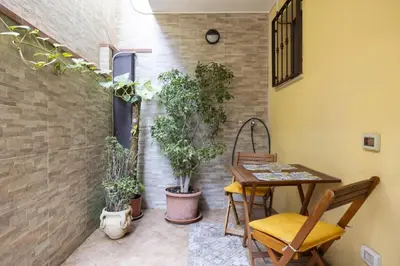 a patio with a table and potted plants at alloggio in Palermo