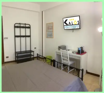 a bedroom with a bed and a desk with a computer at Kalos in Palermo
