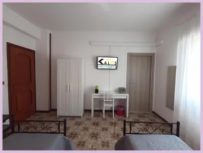 a bedroom with two beds and a table with a sign on the wall at Kalos in Palermo