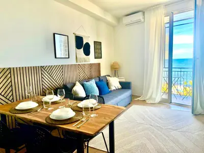 a living room with a table and a blue couch at La Riva - Seashore in Bagheria