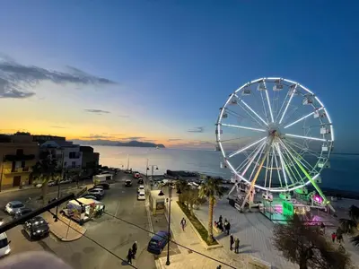 a ferris wheel in a city with a beach at La Riva - Seashore in Bagheria