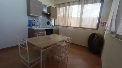a kitchen with a wooden table and chairs in it at Casa Anna in Carini