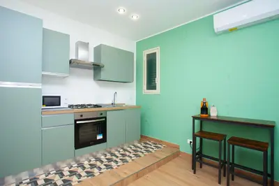 a kitchen with blue cabinets and a counter top at Mondello Twentytwo House in Palermo
