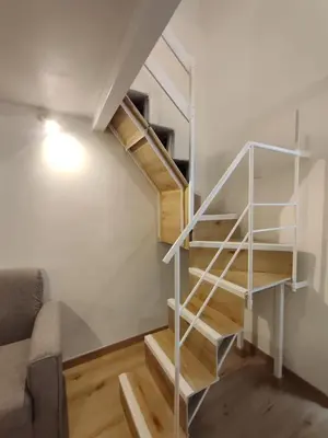 a spiral staircase in a room with a couch at Casa di Tommy in Palermo