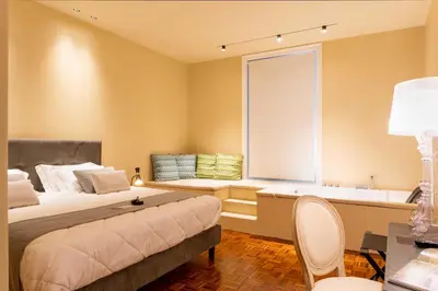 a bedroom with a bed and a window with a bath tub at Five suite in Palermo