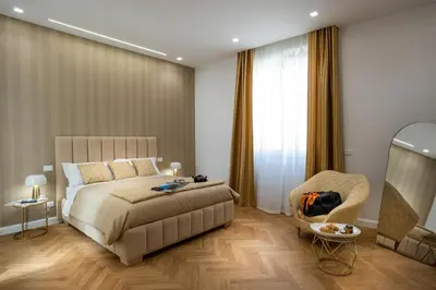 a bedroom with a bed and a chair at Palace Ducrot in Palermo