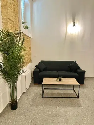 a living room with a black couch and a coffee table at Cala Peppa Loft Butera in Palermo