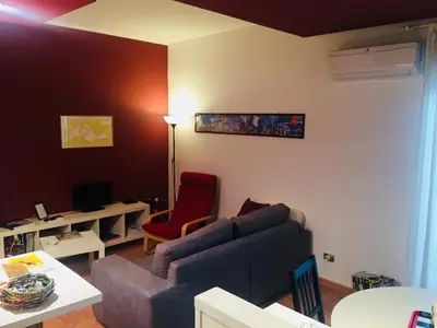 a living room with a blue couch and a red chair at Apartment 