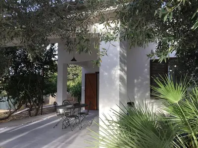 a house with a table and chairs on a patio at Casa Amuri in Scopello
