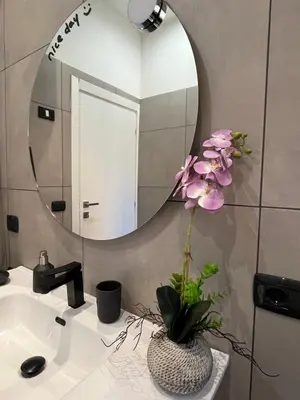 a bathroom with a mirror and a vase with flowers on a sink at Le Terrazze di Chiara in Palermo
