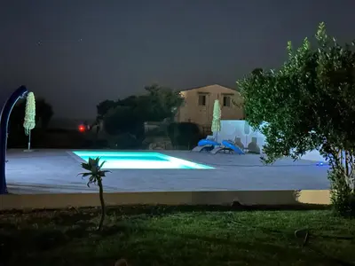 a swimming pool at night with a house in the background at Villa Priscilla in Cinisi