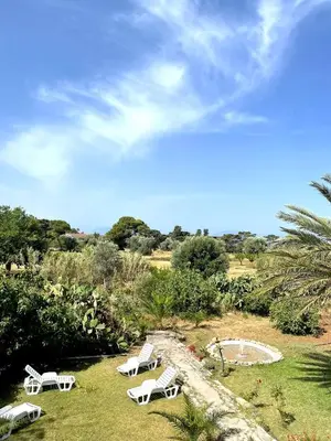 a group of white chairs sitting in the grass at Villa Priscilla in Cinisi