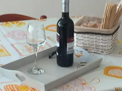 a bottle of wine and a wine glass on a table at Villa Priscilla in Cinisi