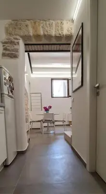 a hallway with a kitchen and a living room at Scopello - Finestra sul cortile in Scopello