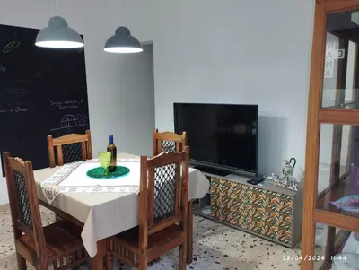 a dining room with a table and a television at La casa di Nanà IL BAGLIO in Palermo