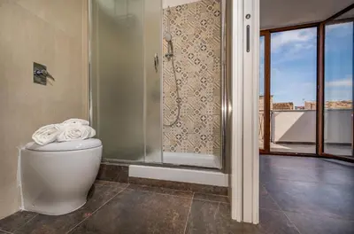 a bathroom with a shower and a toilet with towels at Casa del Golfo Cascio in Castellammare del Golfo