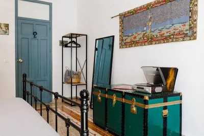 a bedroom with a bed and a green trunk with a printer on it at Ciao Sycylia Apartments in Carini