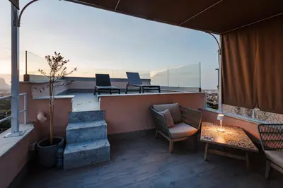 a balcony with a table and chairs on a building at Ciao Sycylia Apartments in Carini