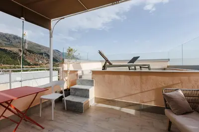 a balcony with stairs and a table and chairs at Ciao Sycylia Apartments in Carini