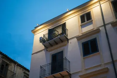 a white building with two balconies on the side of it at La casa di Louis in Palermo