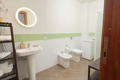 a bathroom with a sink and a toilet and a mirror at Molo Five Apartment in Palermo