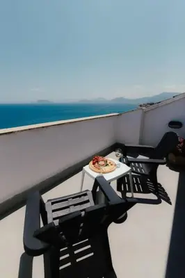 a table and chairs on a balcony with a plate of food at Panoramic apartment on the beach A/C in Palermo
