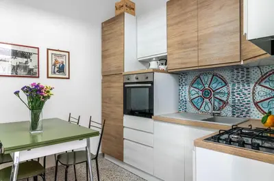a kitchen with white cabinets and a green table at GuestHost - Near Palermo's Historic Heart - Apt with Courtyard in Palermo