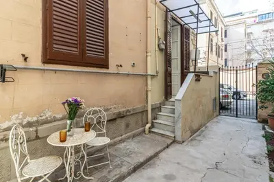 a patio with a table and chairs and stairs at GuestHost - Near Palermo's Historic Heart - Apt with Courtyard in Palermo