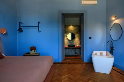 a bedroom with blue walls and a tub and a sink at Belmonte LR Collection in Palermo