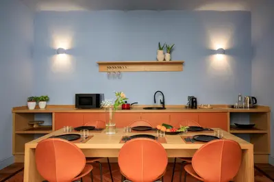 a kitchen with a wooden table and orange chairs at Belmonte LR Collection in Palermo