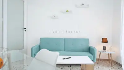 a living room with a blue couch and a table at Licia's home in Palermo